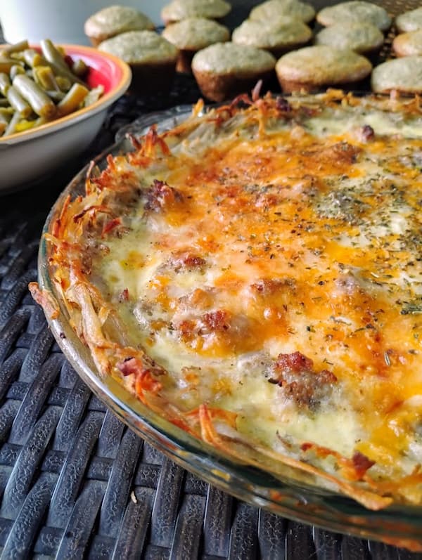 Freshly baked potato crust quiche with a crispy shredded potato crust, topped with melted cheese and herbs.